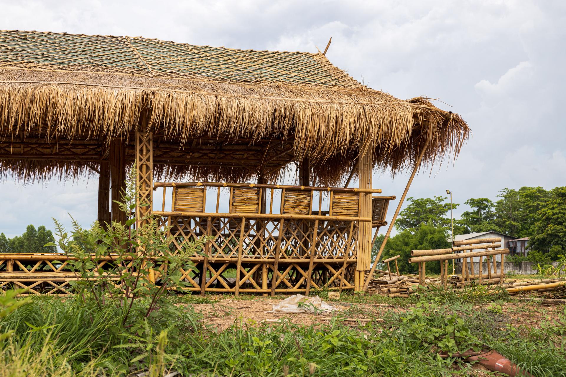 Low angle view of a bamboo frame shelter hut with a vetiver grass roof.