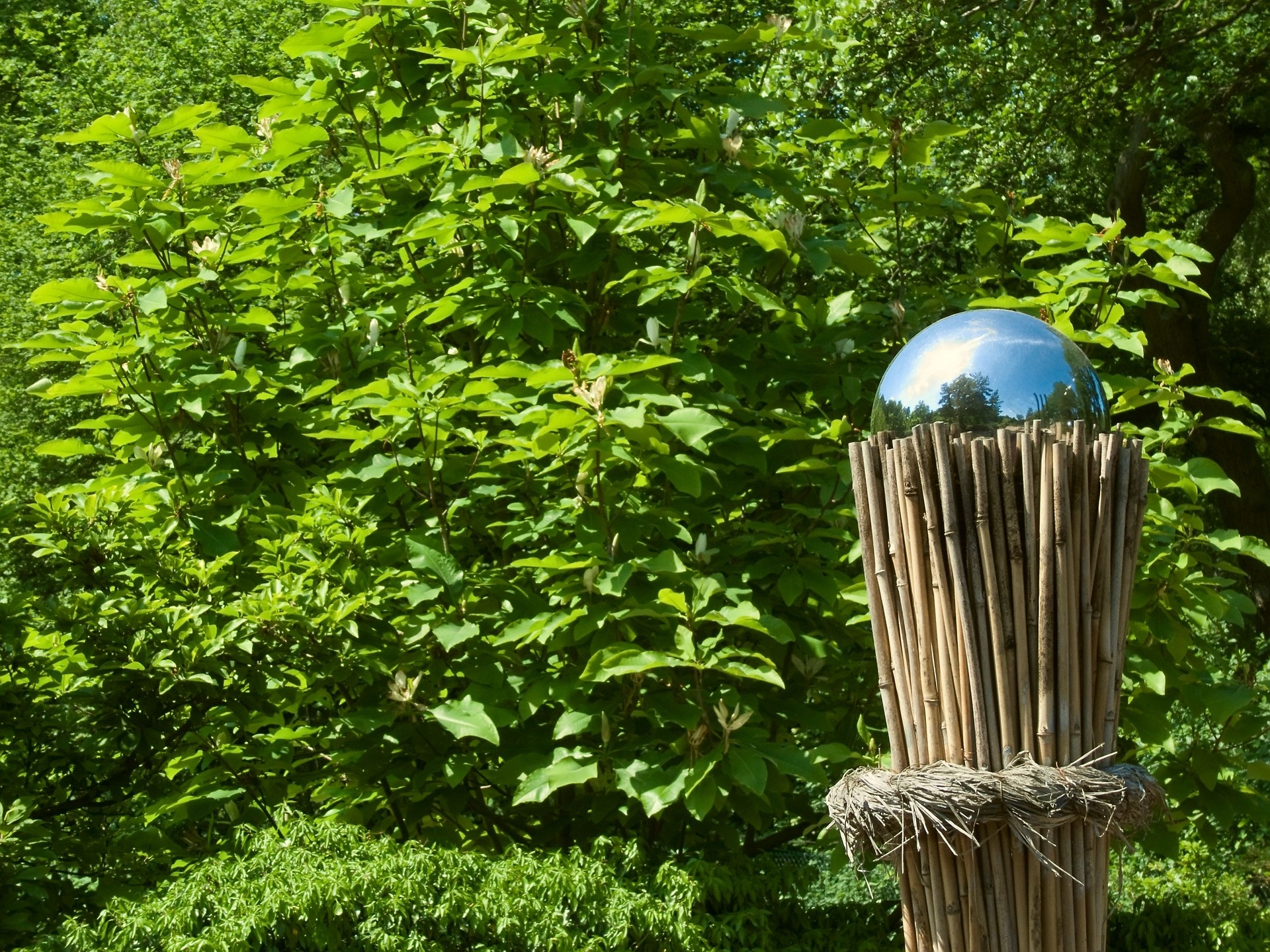 Silver sphere on a bundle of bamboo in the garden